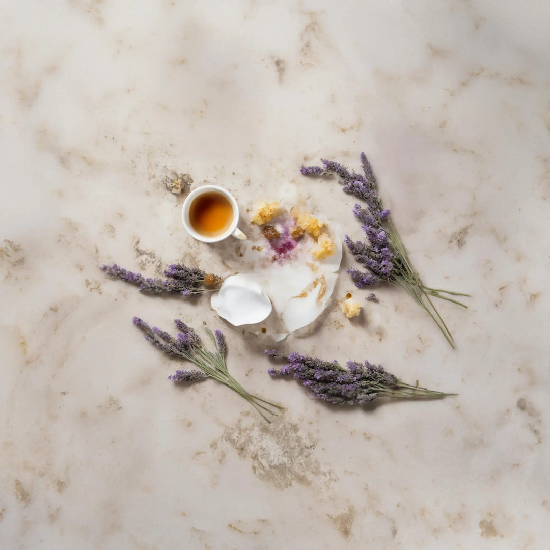 Flat lay of lavender, a teacup, and petals for incorporating herbal teas into routines.